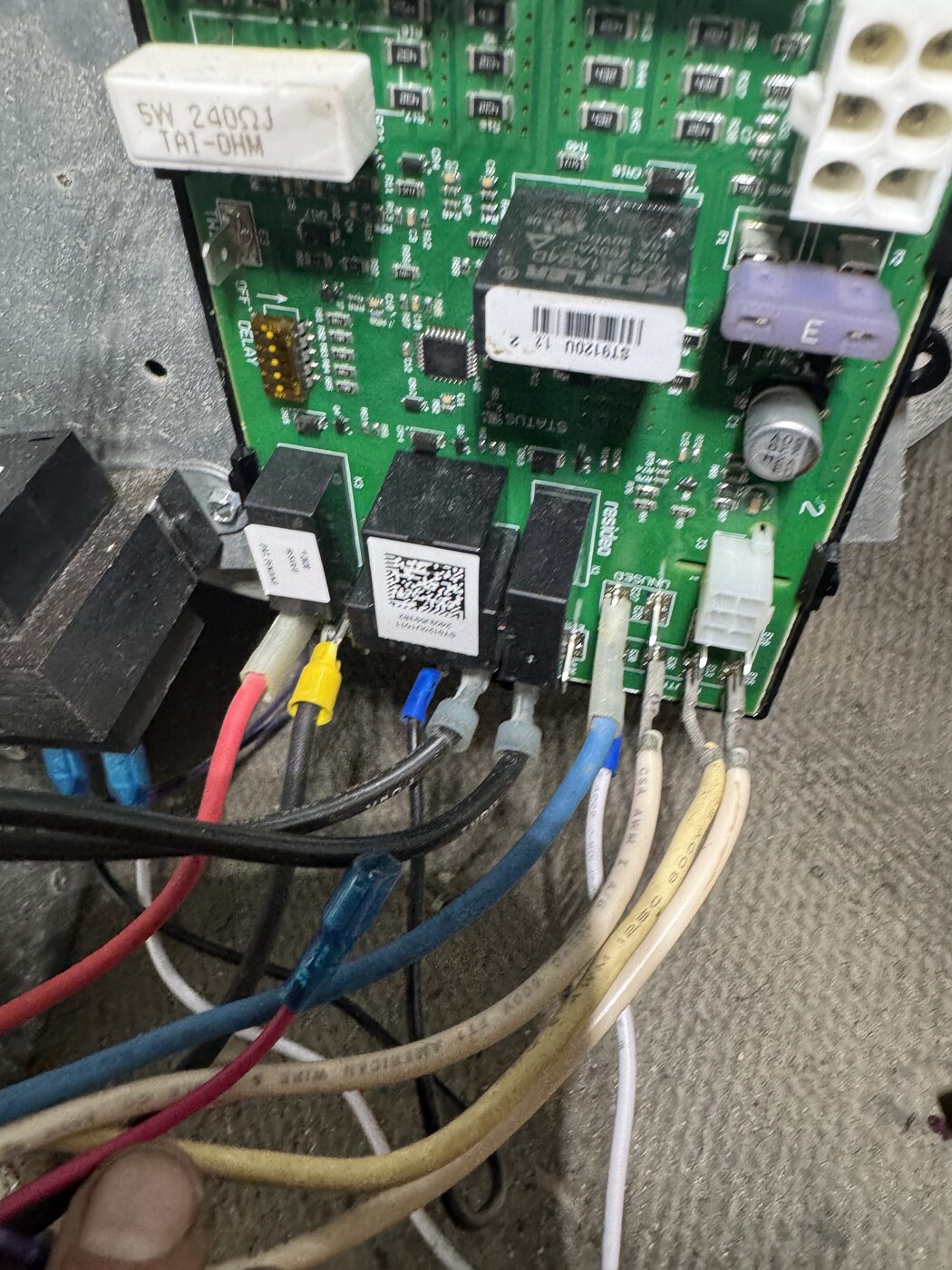 A close look at a control board and its wiring inside an air conditioning unit