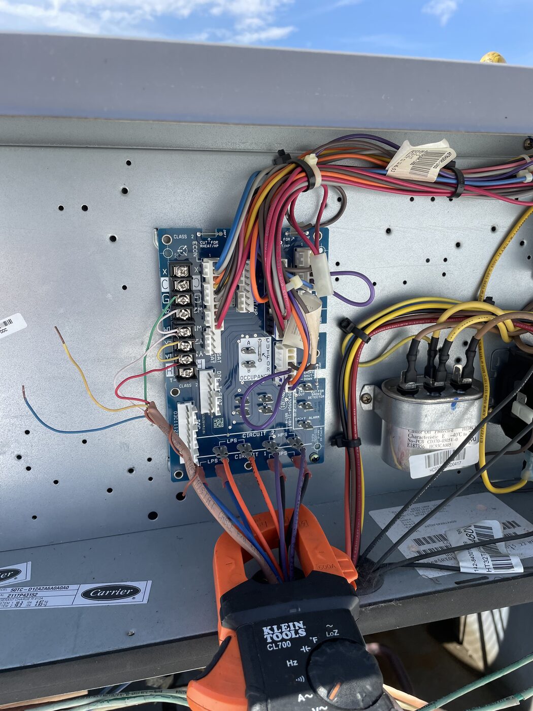 A meter clipped onto the control board wiring inside a commercial unit