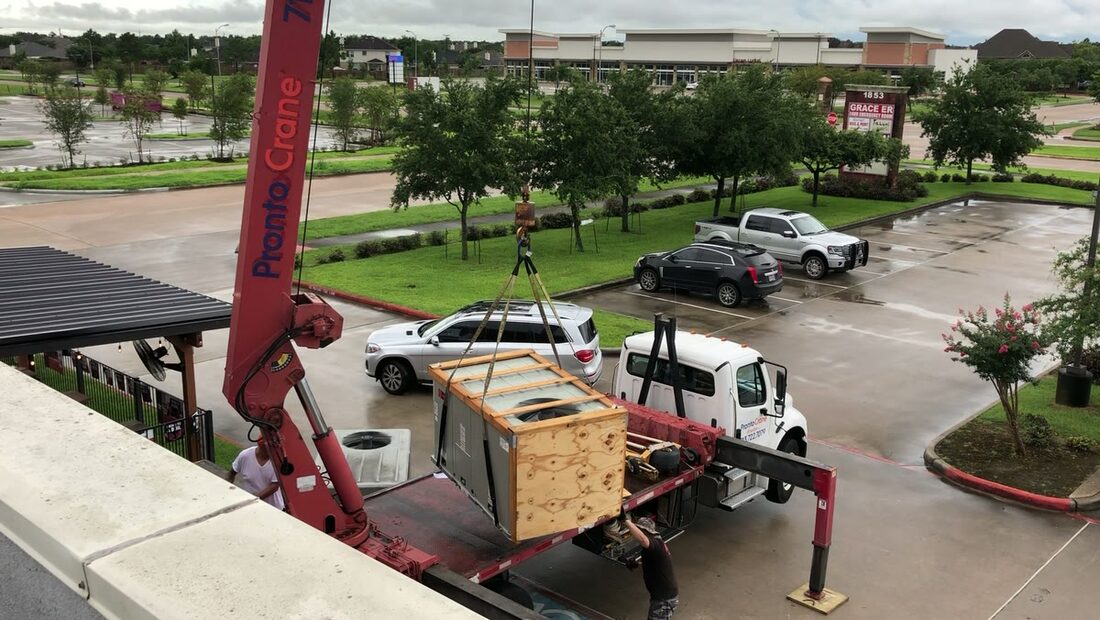 Crane truck set up in the lot, unit crated and ready to go up.