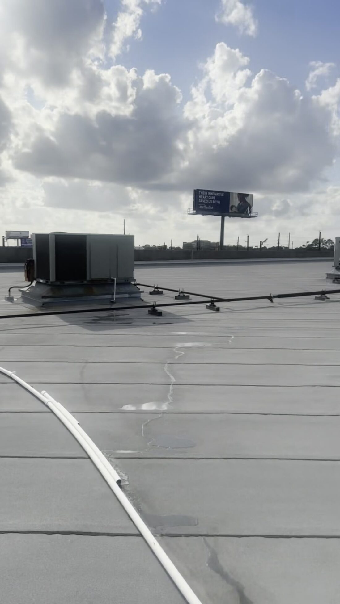 Packaged units on a Houston roof under the kind of sky that breaks them.
